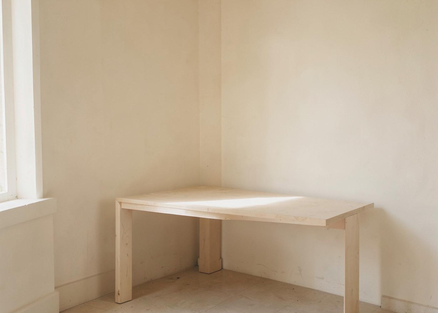 Quiet ivory studio corner with a plain work table