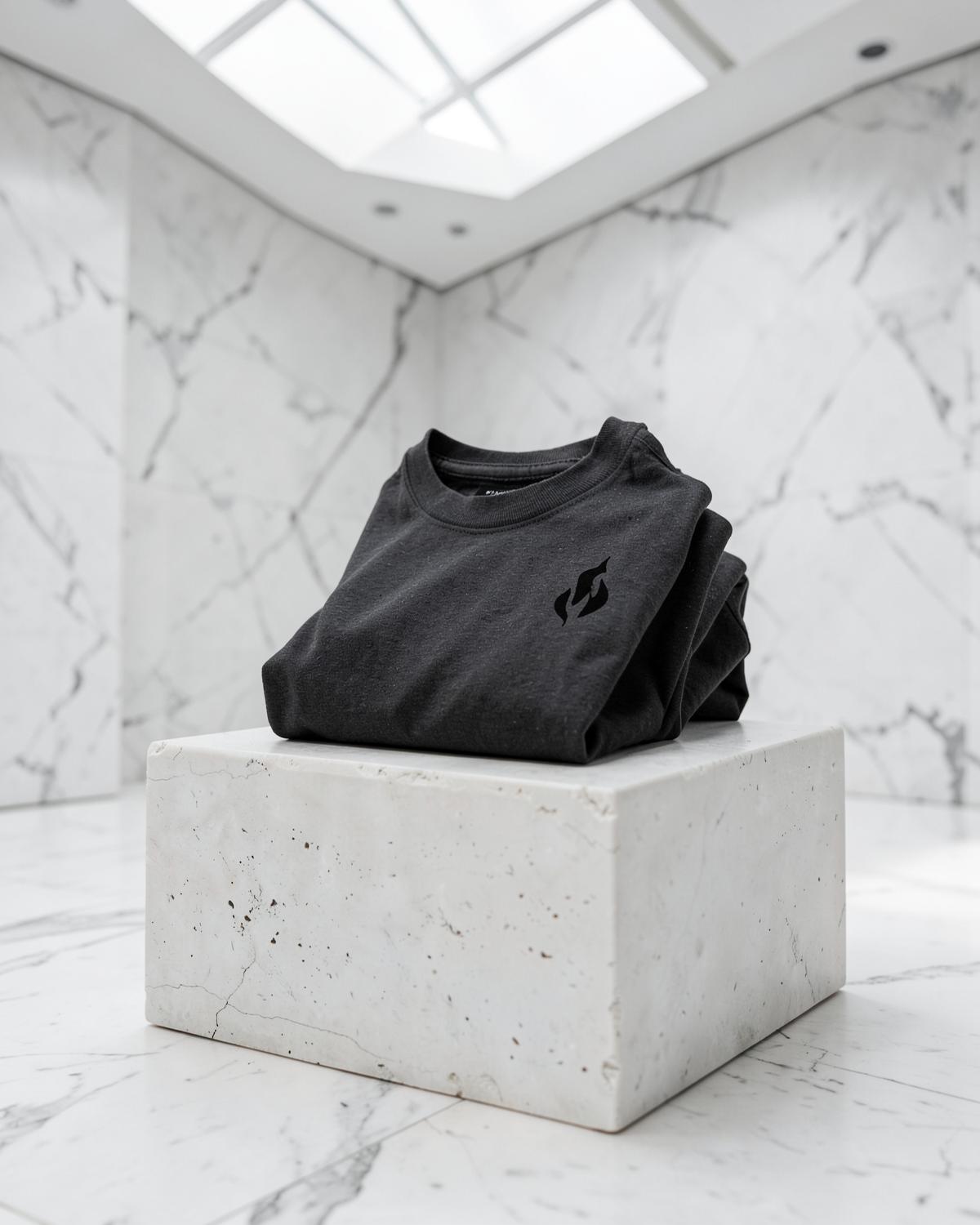 Charcoal apparel displayed on a pale stone plinth